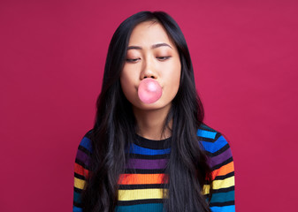 Pretty young woman blowing bubble with chewing gum