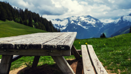 Empty wooden table in front of blurred beautiful outdoor scene in Swiss Alps. Can be used for display or montage your products. Mock up for display of product.