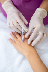 Obraz na płótnie Canvas Beauty doctor making anti-aging injection into arm