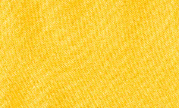 Vibrant yellow texture of binding fabric. Yellow textile background with natural folds. Close-up