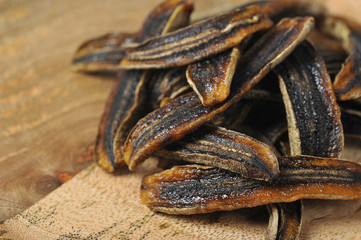 Sun-dried bananas on a wooden surface.  Macro shot.  Free space for text.