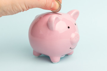 Piggy Bank on white background, space for text. A woman's hand whith coin. Finance, saving money