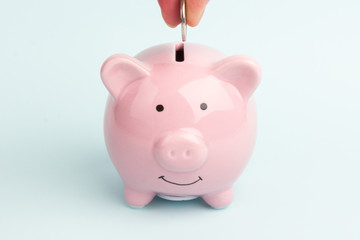 Piggy Bank on white background, space for text. A woman's hand whith coin. Finance, saving money