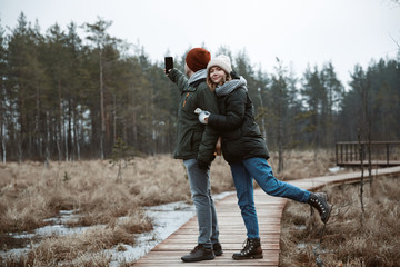 A girl and a guy doing a selfie in nature.