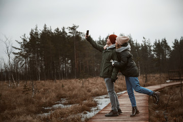 A girl and a guy doing a selfie in nature.