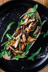 Vegan sandwich with fresh arugula, fried shiitake mushroom and shallot onion.