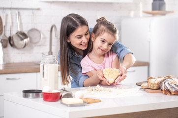 Mom and daughter prepare pastries in the kitchen.