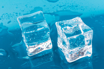 ice cubes and water drops close up on blue background
