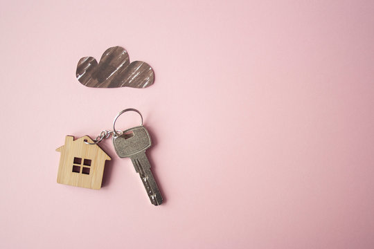 Paper dark cloud above the wooden house and key. Bad times, mortgage, no money concept. Flat lay. Top view