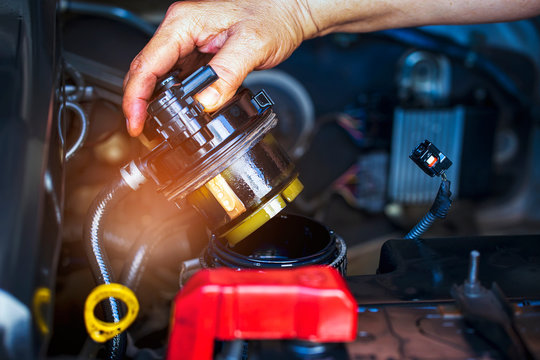 Car mechanic check the fuel filter at diesel engine. service or Preventive maintenance..