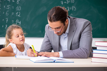 Teacher with young girl in the classroom