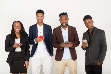 team of young african people in suits on a white background with phones in their hands