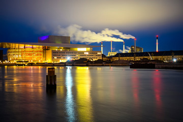 Night view to Copenhagen Opera House Operaen and Amager Bakke factory smoke pipes in Copenhagen, Denmark. February 2020