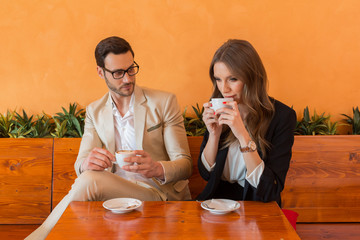Attractive young couple drinking coffee in hotel cafe bar