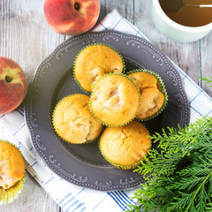 Vegan eggs free spelt wheat muffins with peaches and apples in green paper cases on checkered napkin