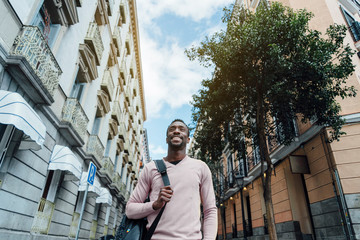 Portrait of handsome hipster african man walking at the street. Lifestyle concept