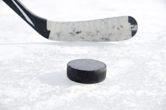 ice hockey stick with black tape and puck