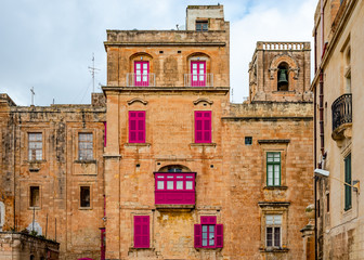 Old houses with colorful wooden balconies in La Valletta, Malta, typical of the traditional Maltese architecture.