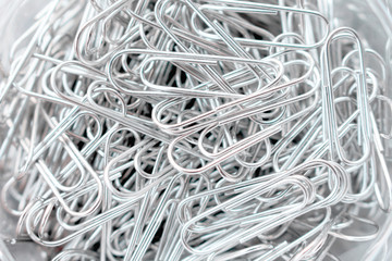 Paper steel clip pile abstract grey background closeup top view