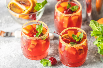 Milano spritzer alcoholic cocktail with red bitter, dry white wine, soda, red orange and ice. Light gray background, bar tools, selective focus