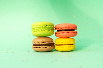Sweet and colourful french macaroons on turquoise.