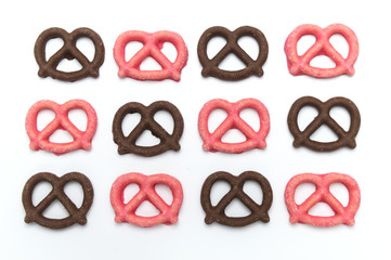 Pretzel with Chocolated biscuit flavored and coated chocolated and strawberry cream on white background.