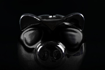 Dark piggy bank against a black background