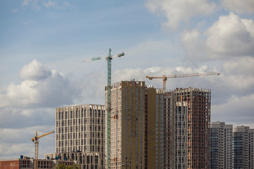 Fototapeta na wymiar Construction site with cranes against the cloudy sky