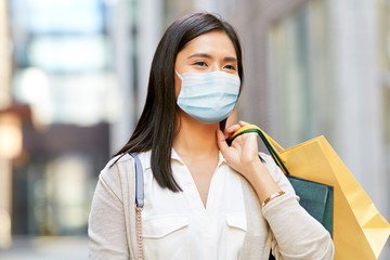 health, safety and pandemic concept - young asian woman wearing protective medical mask for...