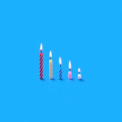 Holiday burning multicolored candles of different height.
