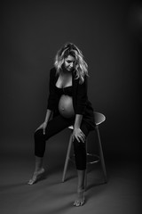 vertical portrait of a young pregnant woman on gray background