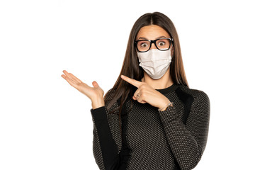 Beautiful advertizing young woman with protective mask on her face on white background