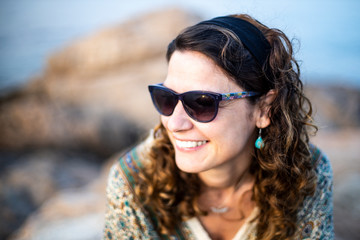 Portrait of a woman with eyeglasses in a rocky coast