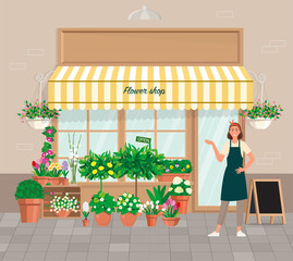 Florist on the background of the facade of the store with flowers in pots.