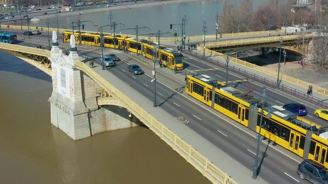 Budapest, Hungary - 4K drone following yellow trams going on Margaret Bridge