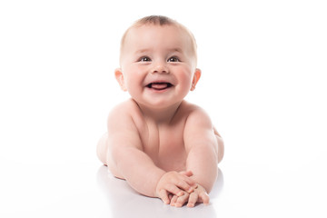 Studio shot of happy 7 months old baby lying on belly, lifting head up. Cut out on white image