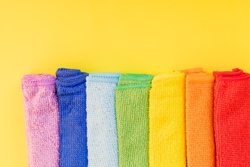 colorful microfiber towels, over yellow background.Cleaning microfiber cloth isolated , Folded cleaning textile napkins colorful stack. Domestic household cleaning service concept.Copy space