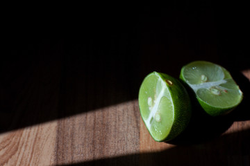 Green sliced lemon under hard sunlight