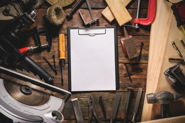 Fix list template. Blank notepad page with copy space and other construction tools on brown wooden...
