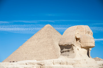 Bright sunny view of the crumbling profile of the Great Sphinx of Giza standing in front of the...