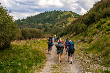 Fototapeta na wymiar A group of tourists on a mountain trail. The concept of travel, adventure or expedition in the mountains.