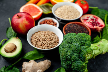 Selection of healthy food:  fruits, seeds, cereals, superfoods, vegetables, leafy vegetables on a stone background. Healthy food for humans