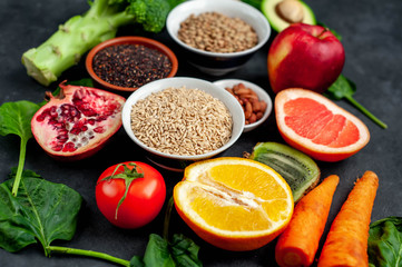 Fototapeta na wymiar Selection of healthy food: fruits, seeds, cereals, superfoods, vegetables, leafy vegetables on a stone background. Healthy food for humans