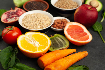 Fototapeta na wymiar Selection of healthy food: fruits, seeds, cereals, superfoods, vegetables, leafy vegetables on a stone background. Healthy food for humans