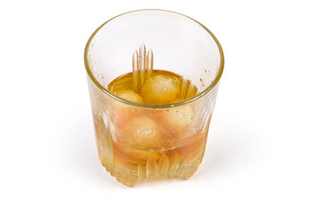 Glass of whisky with ice on a white background