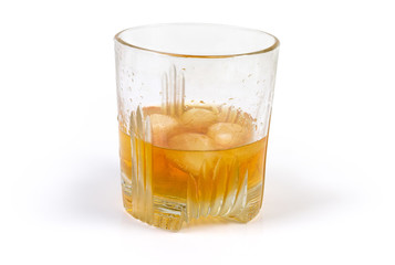 Glass of whisky with ice on a white background
