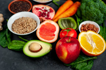 Selection of healthy food:  fruits, seeds, cereals, superfoods, vegetables, leafy vegetables on a stone background. Healthy food for humans