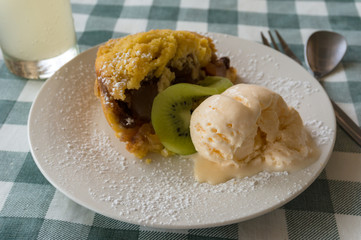 Berry crumble with scoop of vanilla ice cream and kiwi fruit