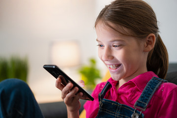 Young Little Girl Using Smartphone and Smiling Portrait With Copyspace