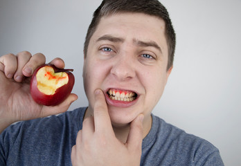 A man bit an apple and blood came out of his gums. Gum bleeding, symptoms of gingivitis,...